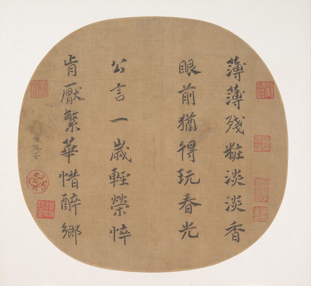 A semicircularly framed piece of light brown fabric paper features vertical columns of Chinese calligraphy written in black ink. Several red seals or stamps are placed around the edges.
