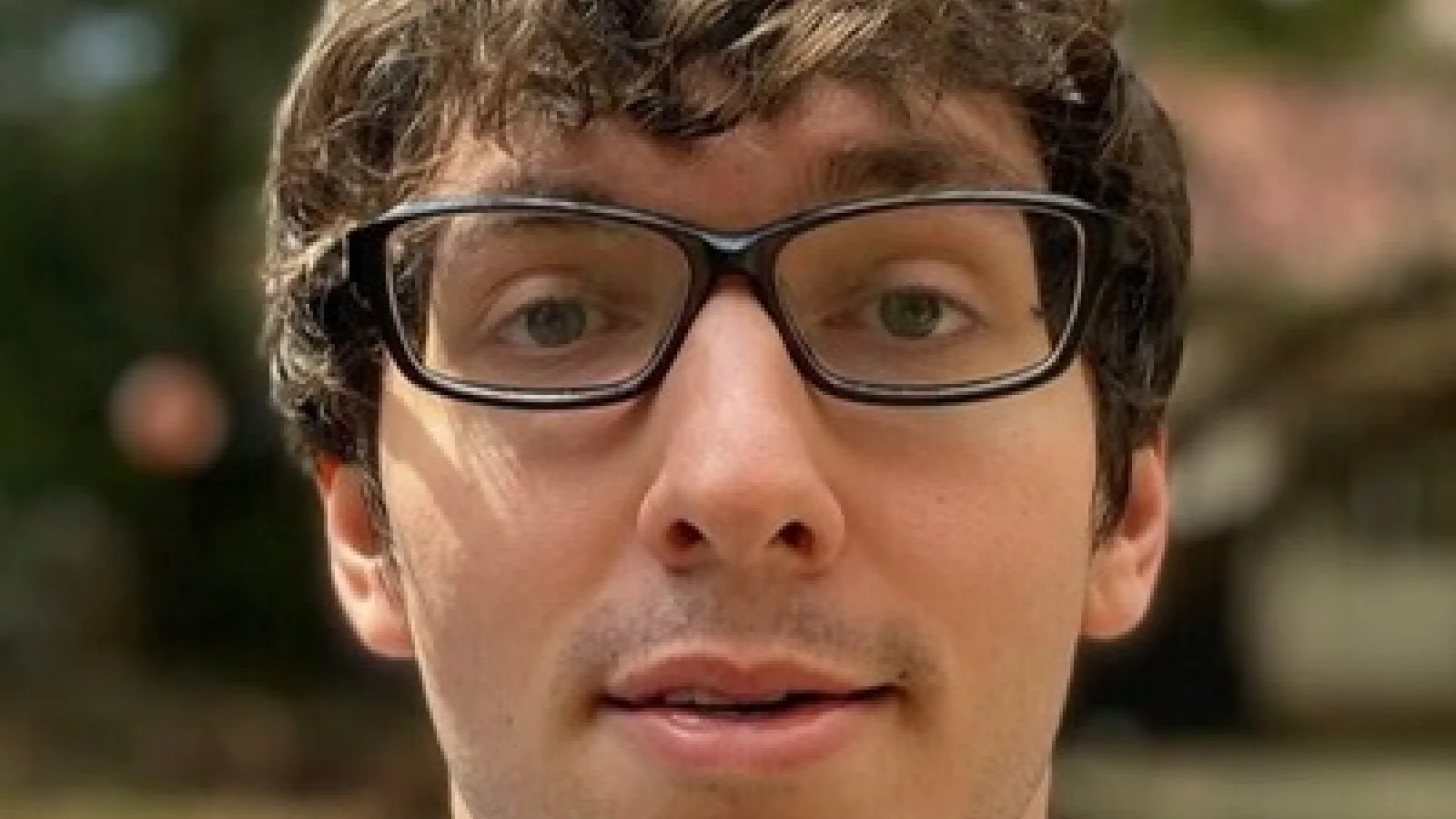 Dark haired man with glasses and collared shirt