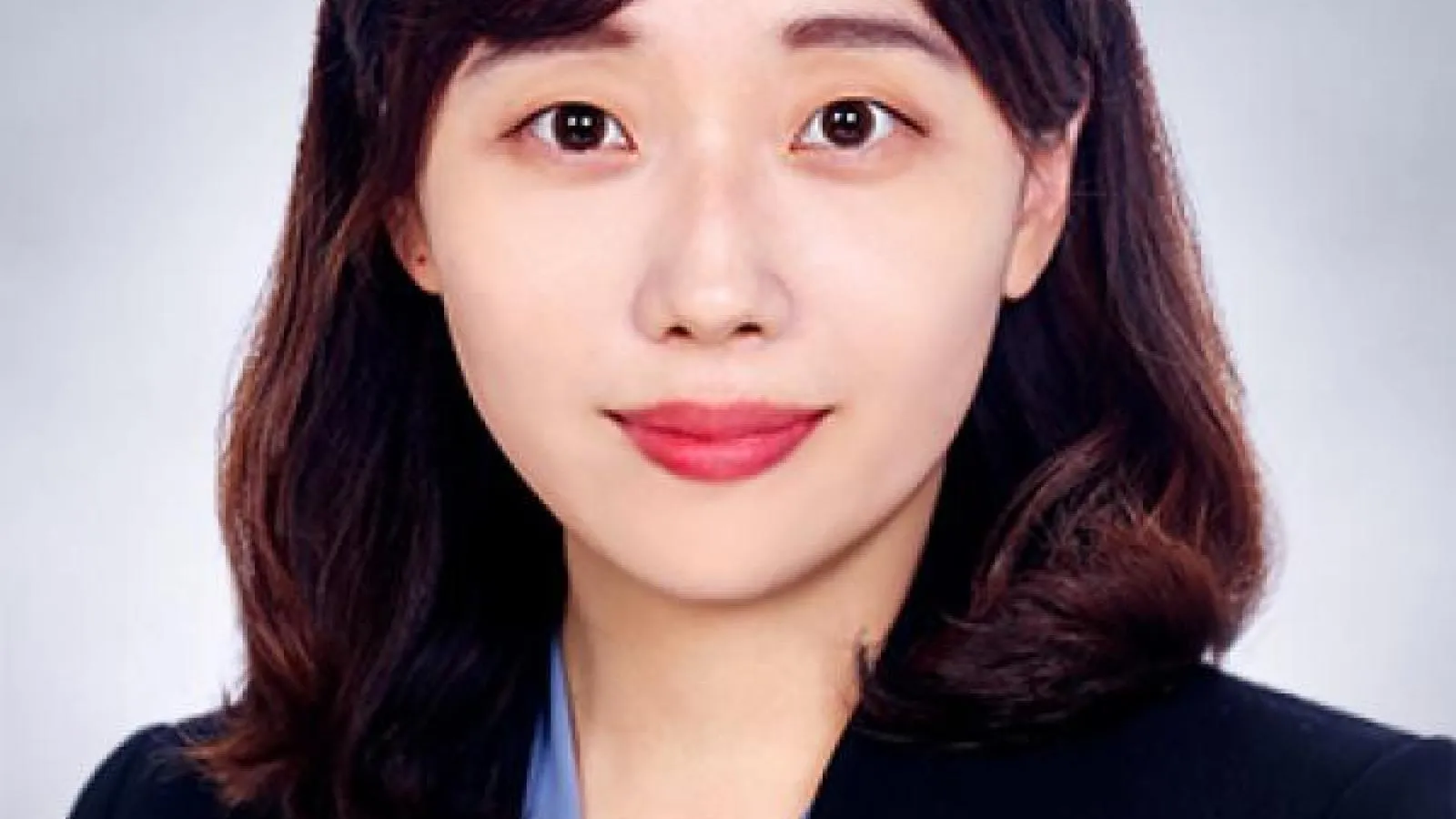 Woman with dark hair looking towards camera.