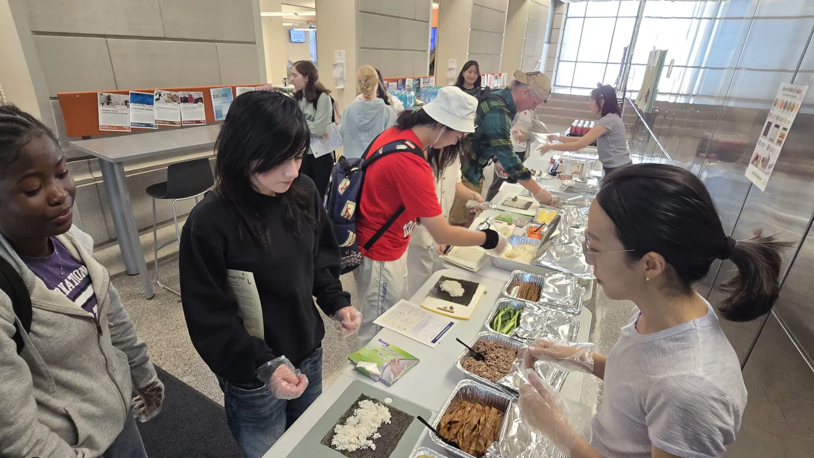 Professor talks to students at an information table