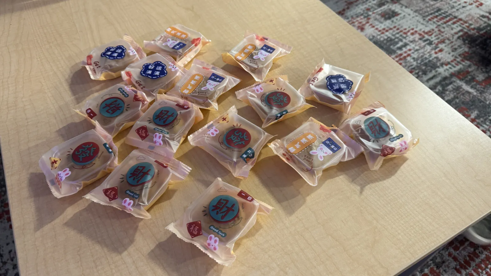 a desk with a many individually wrapped mooncakes