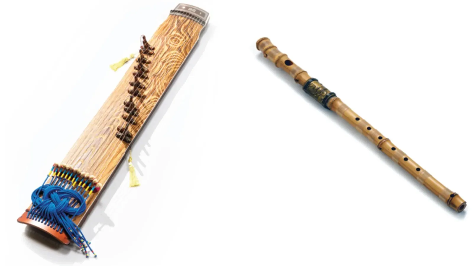 Two traditional wooden musical instruments: a long string instrument with blue tassels and a slender holed wind instrument.