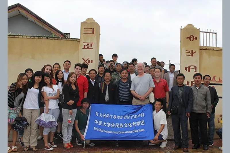 "Professor Mark Bender (above right side of banner) with Ohio State students on 2012 China Global May Education Abroad program with students of Professor Aku Wuwu, Southwest Minzu University, Chengdu, visiting an upland village in the Liangshan Yi Autonomous Prefecture, Sichuan, PRC."