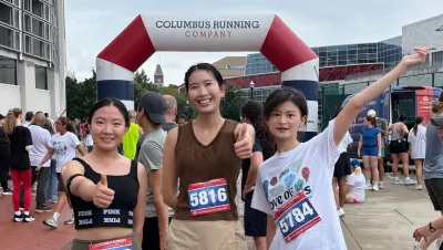 3 women smiling at race finish line