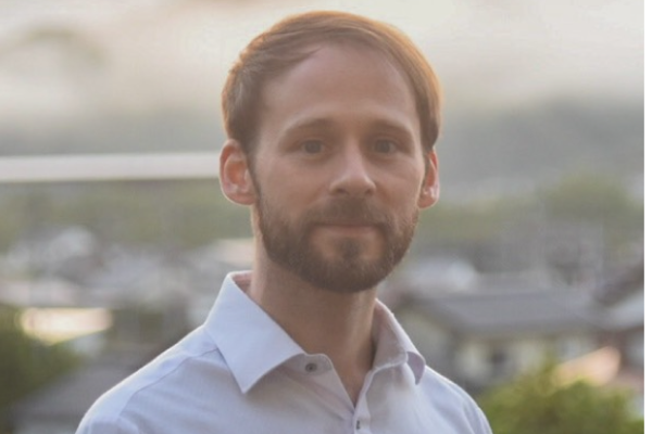  Picture of Derek Reiman, Dark haired man with beard, wearing light colored collared shirt