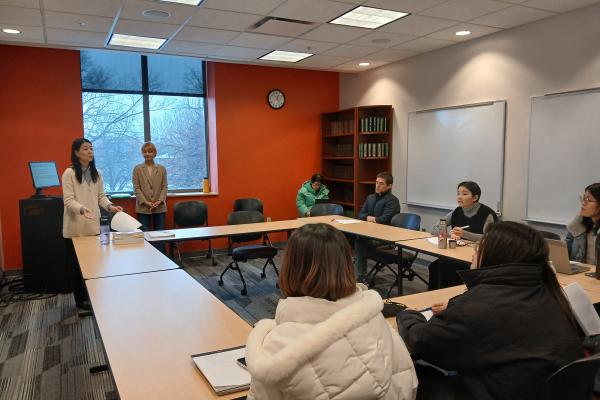 Several people seated at a table, actively participating in a classroom discussion.