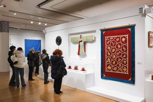 A group of people observing various artworks displayed in a museum gallery. 