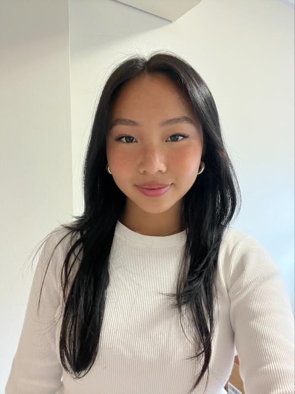Young woman wearing a white sweater, smailing and relaxed